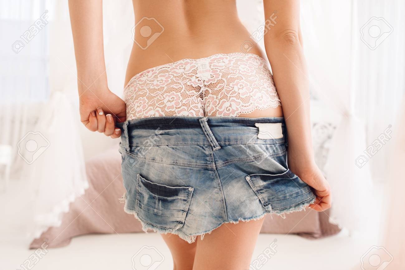 Woman Take Down Her Denim Mini Skirt In Bedroom. Lady With Perfect Body Erotically Undressing. Love, Sex, Seduction, Passion Concept Stock Photo, Picture And Royalty Free Image