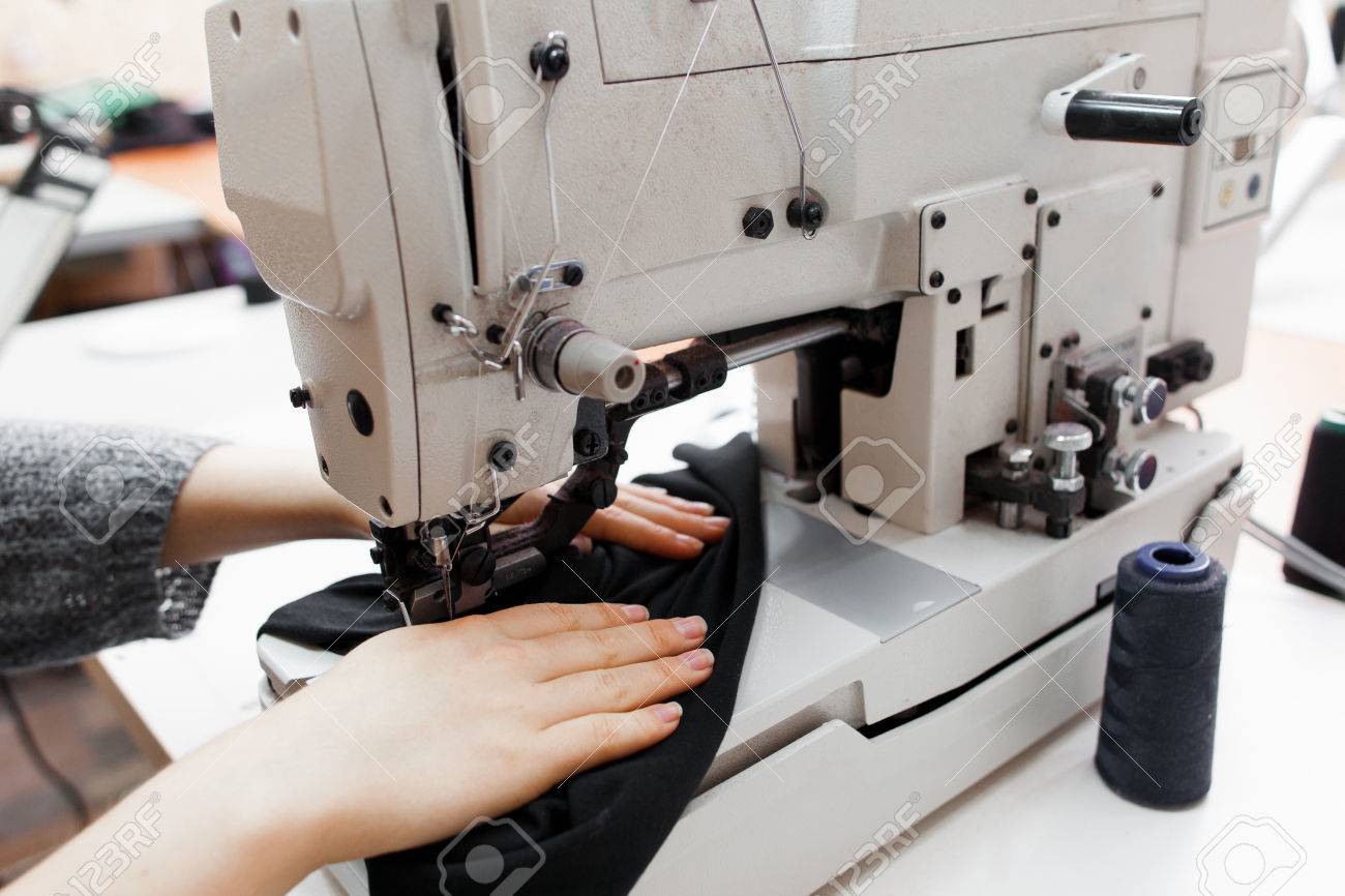 Woman stitching dark fabric on sewing machine. Close-up of seamstress hands making clothes on professional equipment. Garment industry, designer atelier, tailoring process concept - 66785688 Woman stitching dark fabric on sewing machine. Close-up of seamstress hands making clothes on professional equipment. Garment industry, designer atelier, tailoring process concept - 66785688