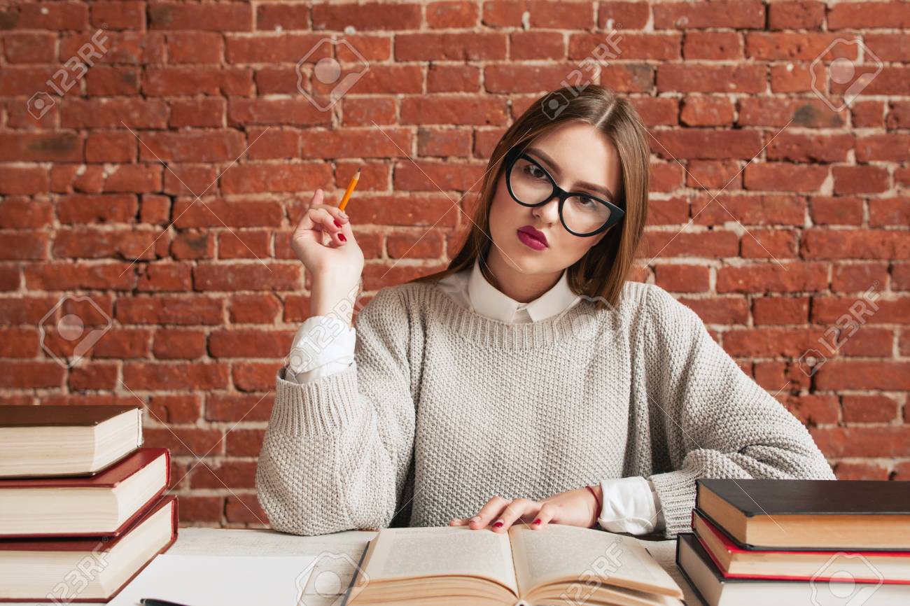 デスク無料スペースで物思いにふける美女の肖像画 教材について考える若い学生女です 教育 研究 概念の学習 の写真素材 画像素材 Image