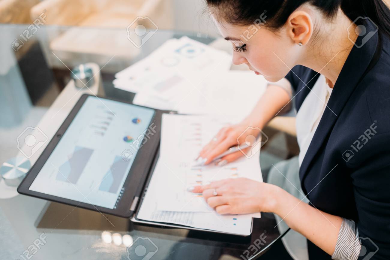 business analyst studying report papers with graphic results processing analyst