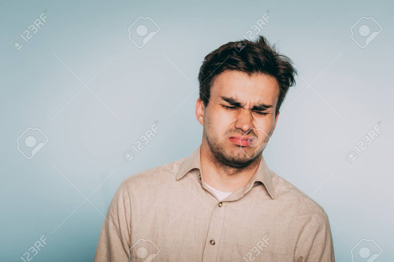 Nausea Aversion Repulsion. Reluctant Man Grimacing In Disgust. Portrait Of  A Young Brunet Guy On Light Background. Emotion Facial Expression. Feelings  And People Reaction Concept. Stock Photo, Picture and Royalty Free Image.