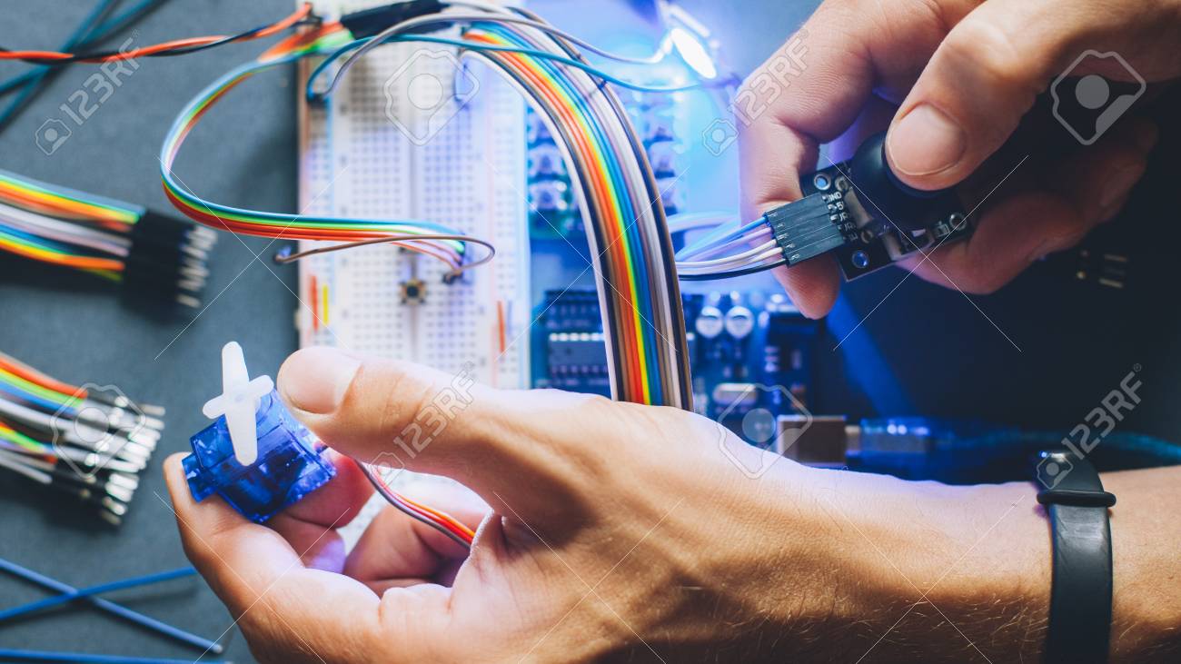 Engineer inventing prototype. Robotic electronic module construction. Microcontroller programming. Hands working with electrical sensor. - 121284361 Engineer inventing prototype. Robotic electronic module construction. Microcontroller programming. Hands working with electrical sensor. - 121284361