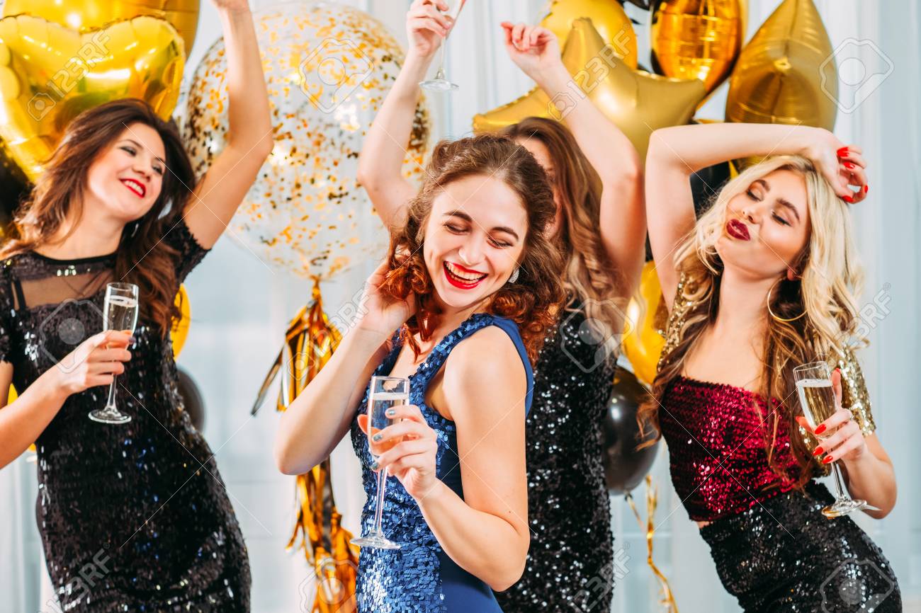 Fancy party. Ladies celebrating their college graduation at home. Girls dancing with champagne in room decorated with balloons. - 121495133 Fancy party. Ladies celebrating their college graduation at home. Girls dancing with champagne in room decorated with balloons. - 121495133