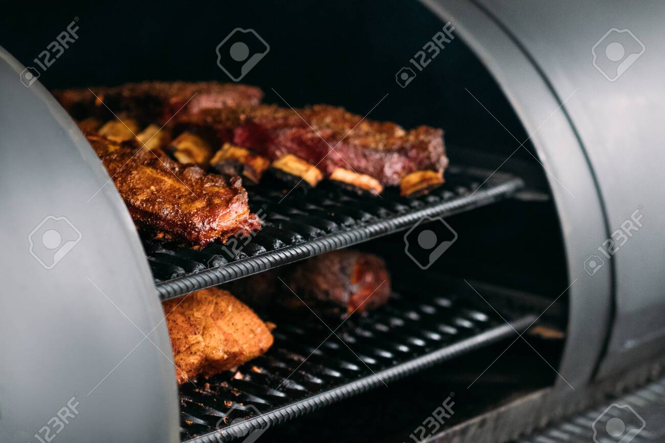 Professional kitchen appliance. Poultry, beef and pork meat, ribs cooked in BBQ smoker. - 129911729 Professional kitchen appliance. Poultry, beef and pork meat, ribs cooked in BBQ smoker. - 129911729