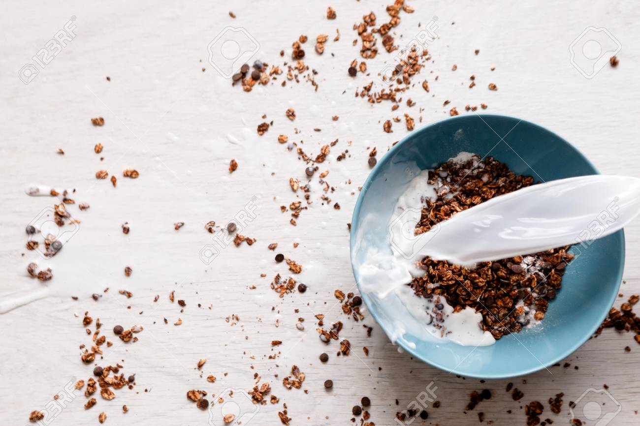 健康的な穀物朝食の料理 白い背景の上のミルクと甘いグラノーラ 全粒ベジタリアン朝おいしいです の写真素材 画像素材 Image