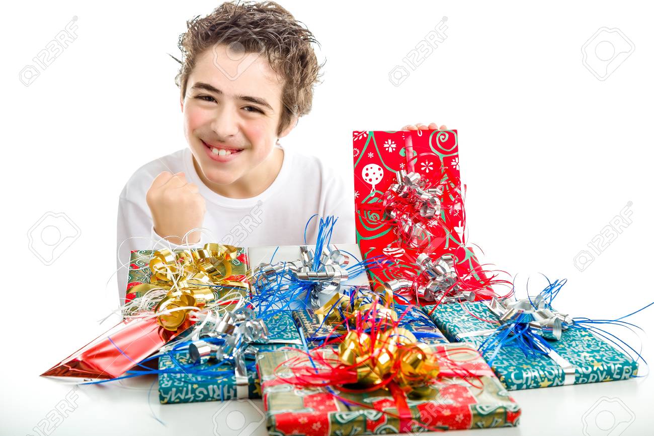 Regali Di Natale Divertenti.Immagini Stock Un Ragazzo Felice Fa Segno Di Successo Ricevendo Numerosi Regali Di Natale In Confezioni Divertenti E Nastri Colorati Image 37198822