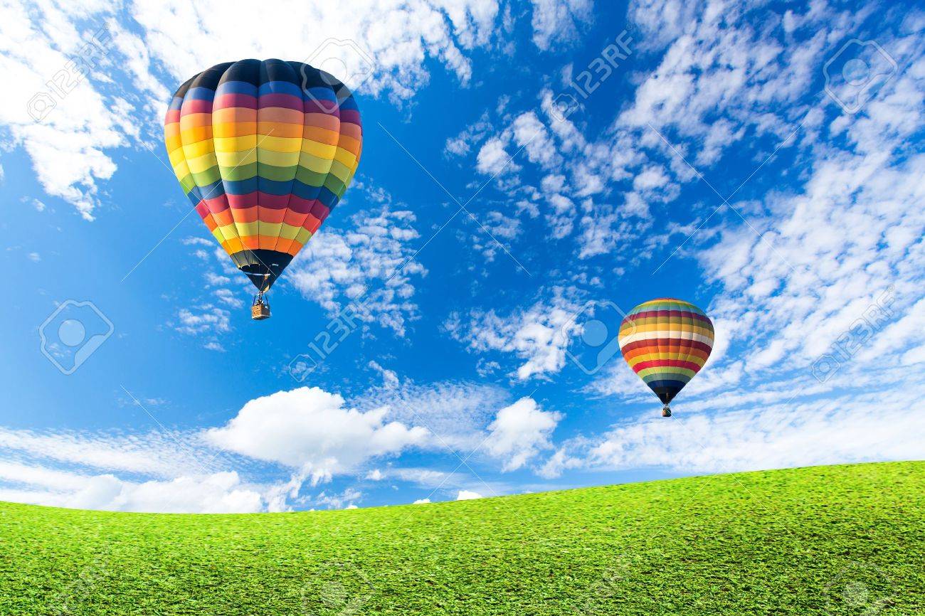 Colorful hot air balloon over green fields - 19722965 Colorful hot air balloon over green fields - 19722965