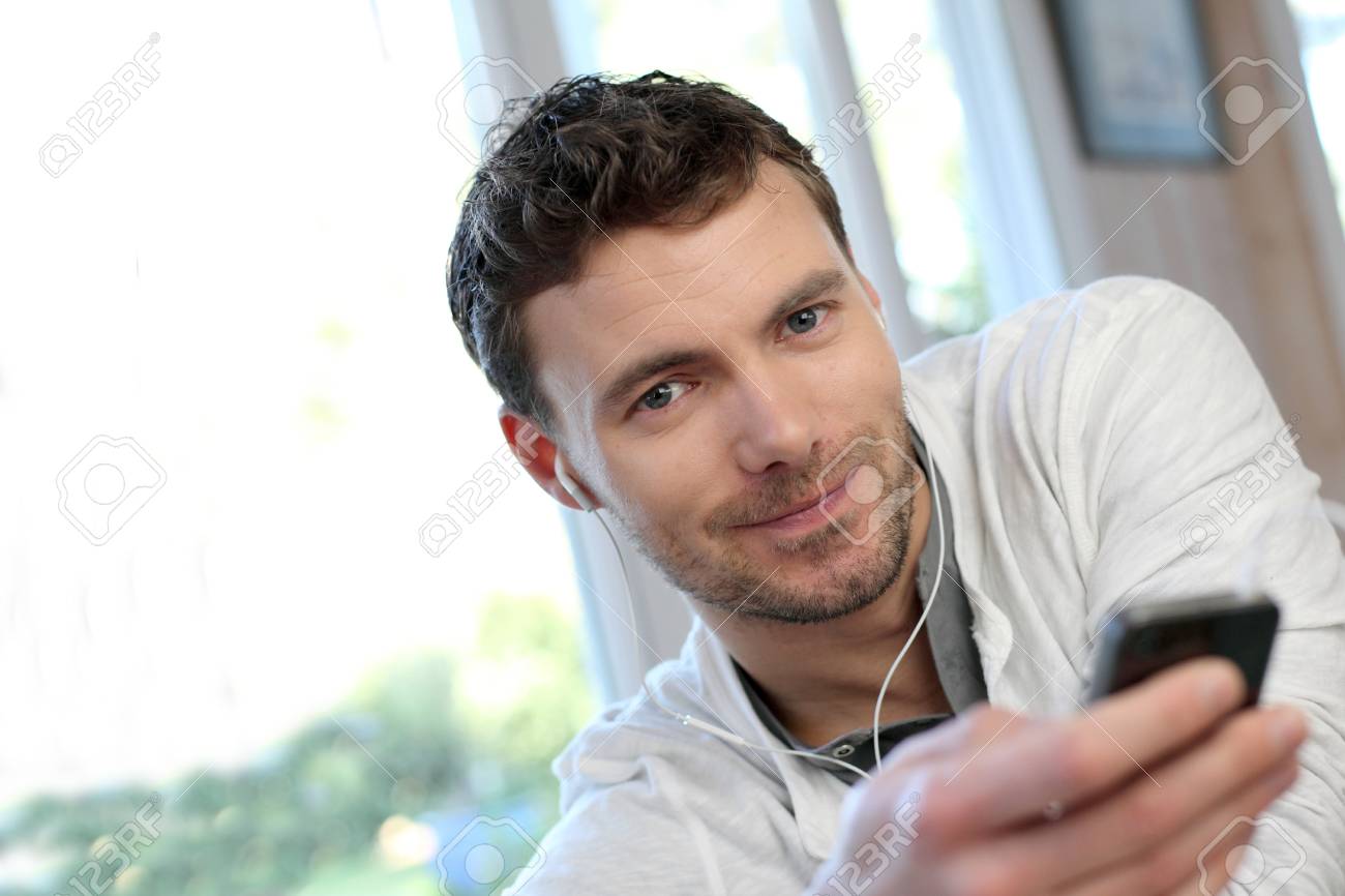 ハンズフリー ヘッドセットと携帯電話を使用して若い男 の写真素材 画像素材 Image