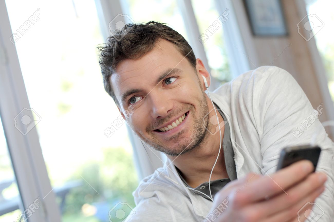 若い男がハンズフリー ヘッド セットと携帯電話を使用して の写真素材 画像素材 Image