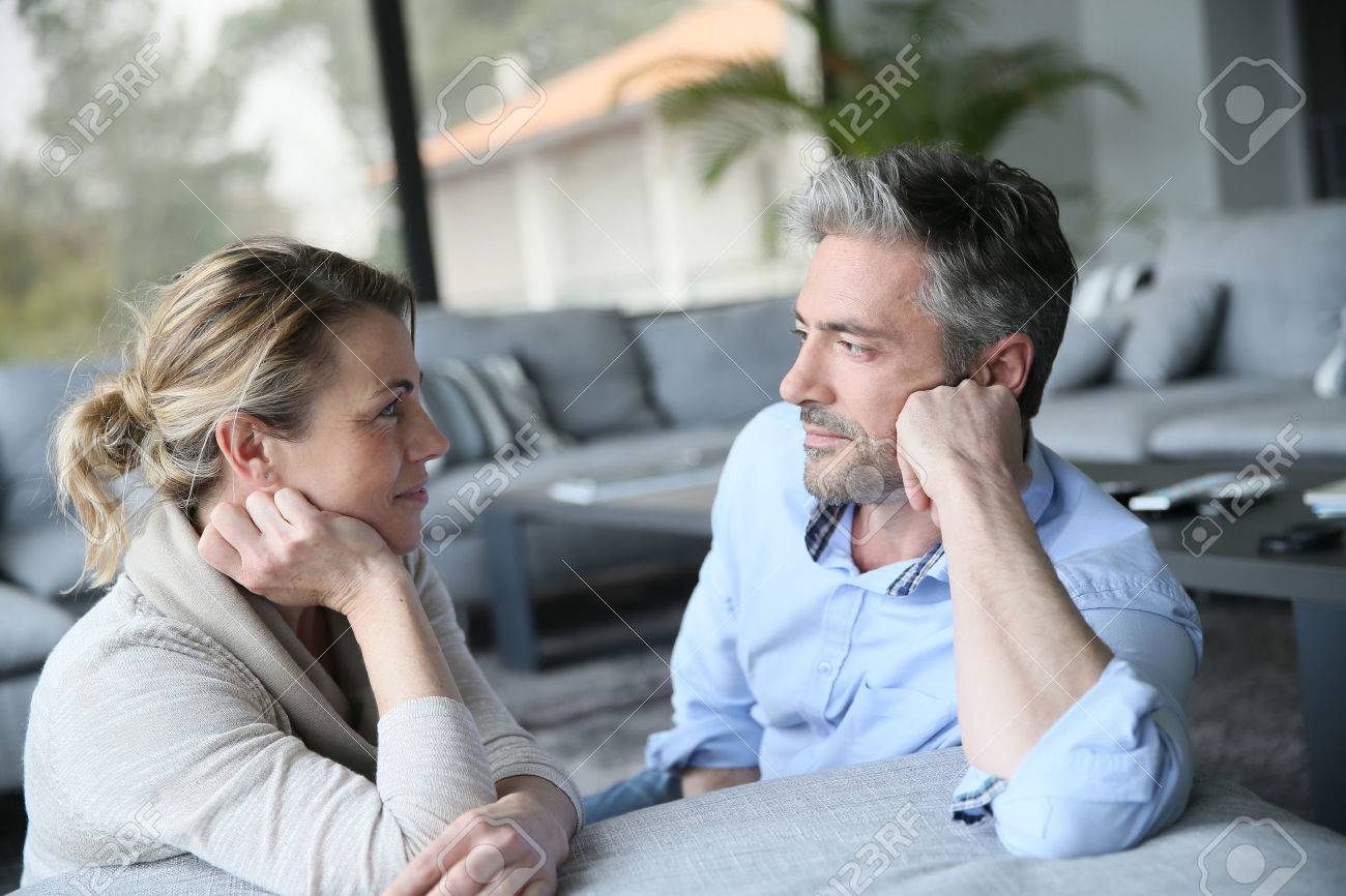 mature couple talking to each other in sofa stock photo picture and