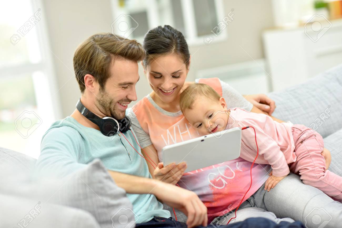 Couple Avec Bebe Dans Le Canape En Regardant Le Film Sur Tablette Banque D Images Et Photos Libres De Droits Image