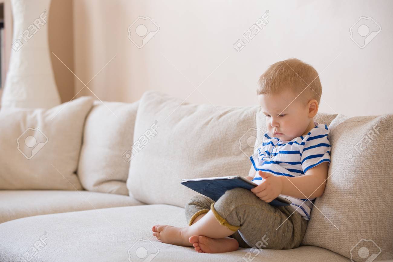 Adorable Blond Bebe Garcon Allonge Sur Le Canape Et Jouer Avec La Tablette Pc A La Maison A L Interieur Enfant Avec Ordinateur Tablette Banque D Images Et Photos Libres De Droits Image