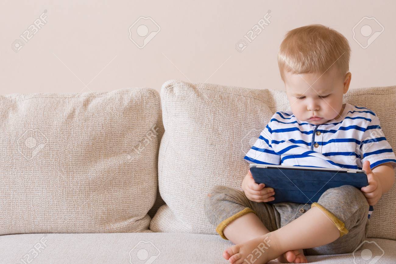 Adorable Blond Bebe Garcon Allonge Sur Le Canape Et Jouer Avec La Tablette Pc A La Maison A L Interieur Enfant Avec Ordinateur Tablette Banque D Images Et Photos Libres De Droits Image