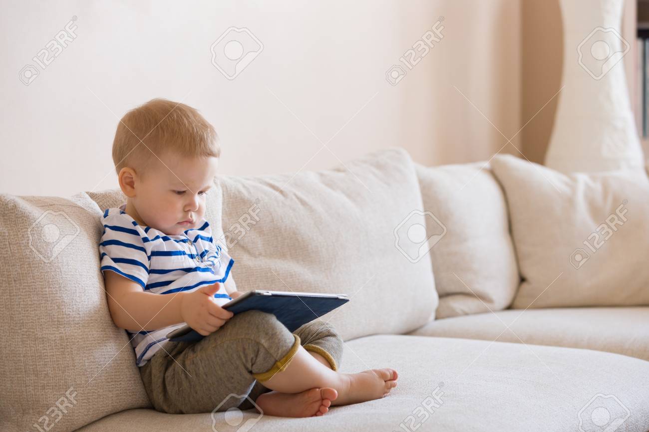 Adorable Blond Bebe Garcon Allonge Sur Le Canape Et Jouer Avec La Tablette Pc A La Maison A L Interieur Enfant Avec Ordinateur Tablette Banque D Images Et Photos Libres De Droits Image