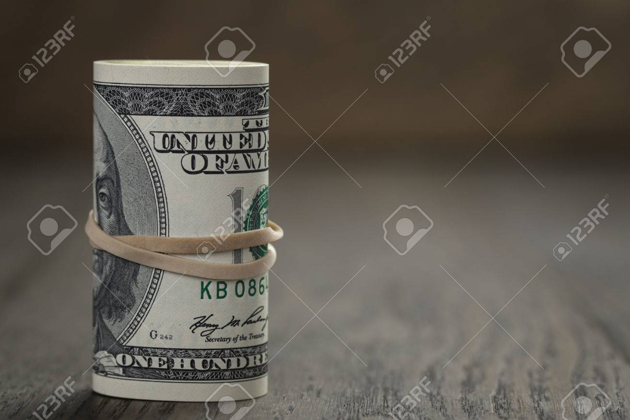 roll of old style hundred dollar bills stand on wooden table - 37907506 roll of old style hundred dollar bills stand on wooden table - 37907506