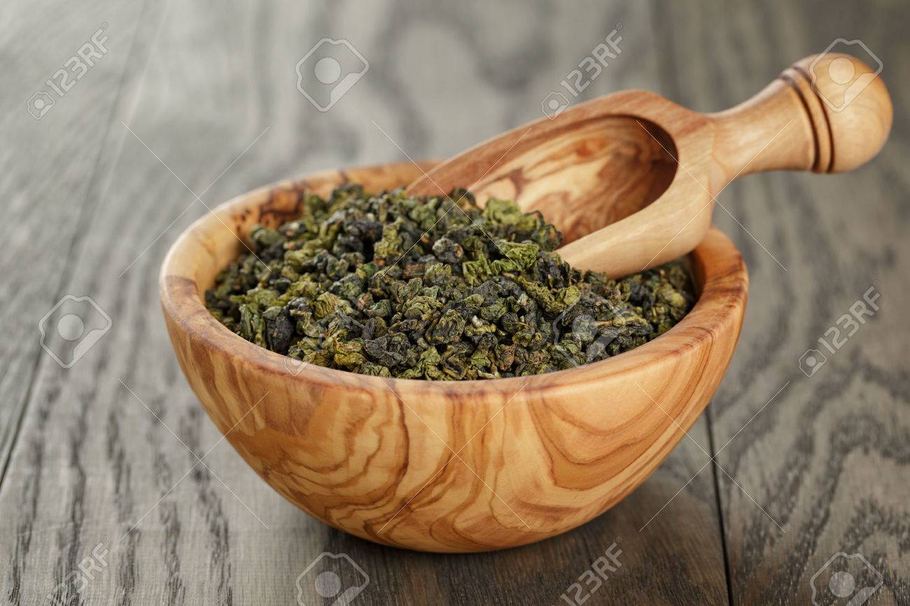 oolong green tea in wood bowl, on oak table - 42909519 oolong green tea in wood bowl, on oak table - 42909519