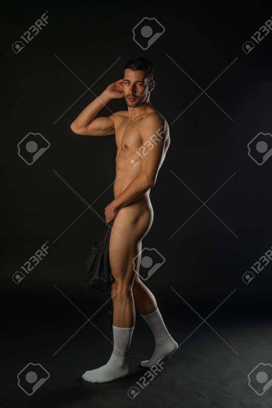 Full-length Picture In A Dark Studio Of A Handsome Naked Man Posing In  White Socks Stock Photo, Picture and Royalty Free Image. Image 181251584.