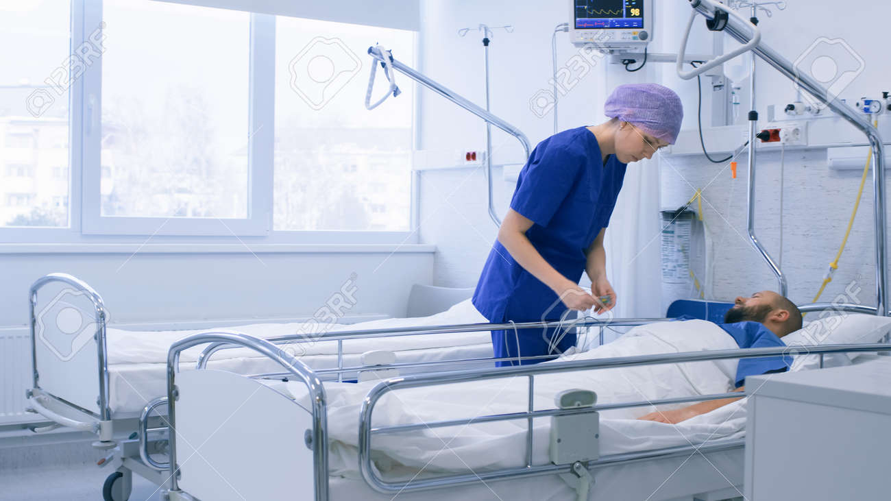 In the Hospital Medical Ward Nurse Takes Care of a Patient Lying in Bed. Clean Modern Hospital with Friendly and Professional Staff. - 158961918 In the Hospital Medical Ward Nurse Takes Care of a Patient Lying in Bed. Clean Modern Hospital with Friendly and Professional Staff. - 158961918
