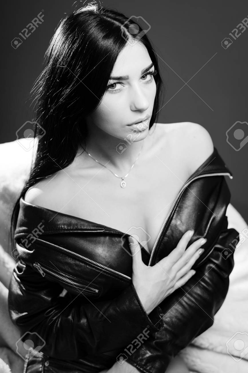Black and white photography portrait of hot sexy pretty lady wearing leather jacket sensually looking at