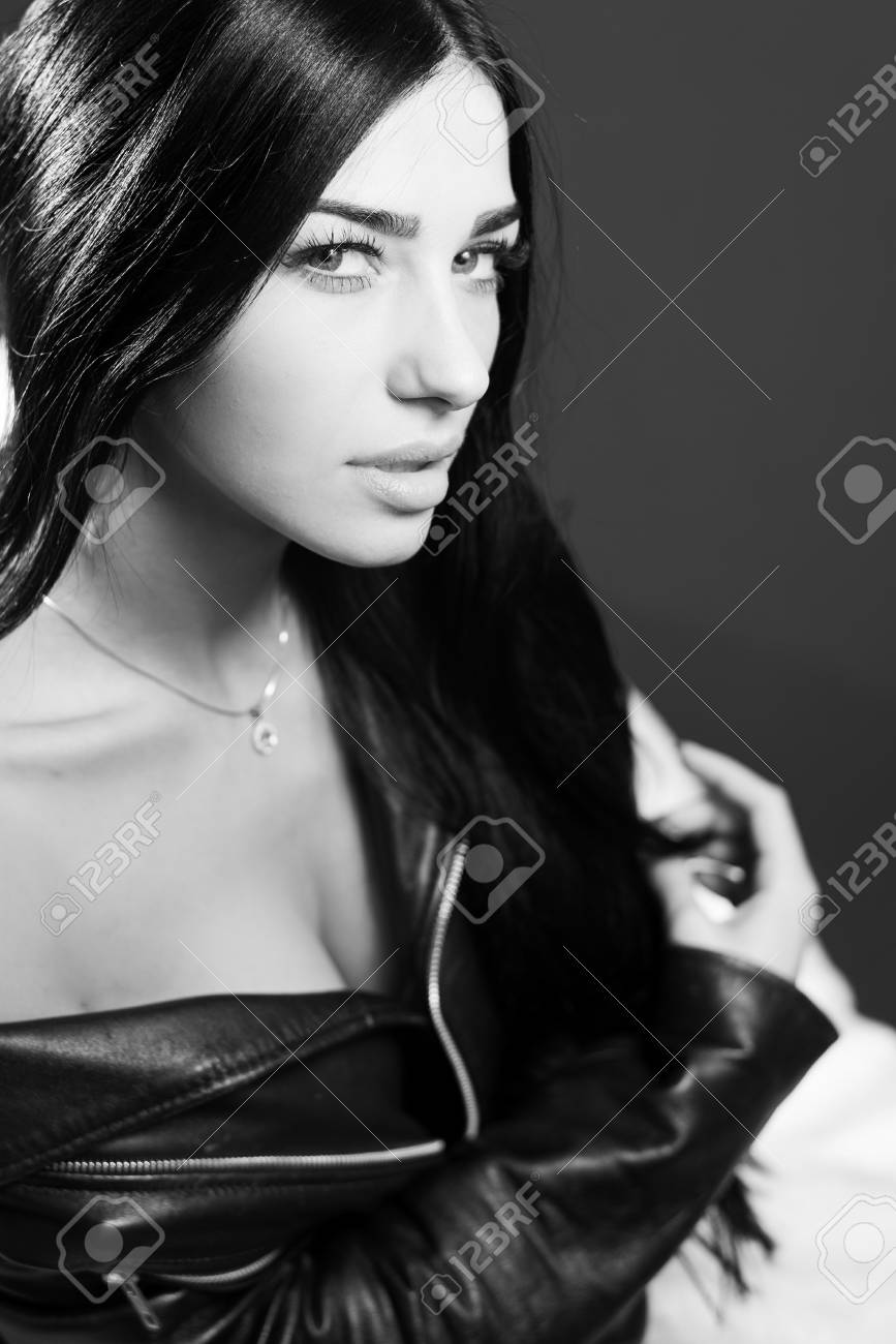 Black and white photography portrait of hot sexy pretty lady wearing leather jacket sensually looking at