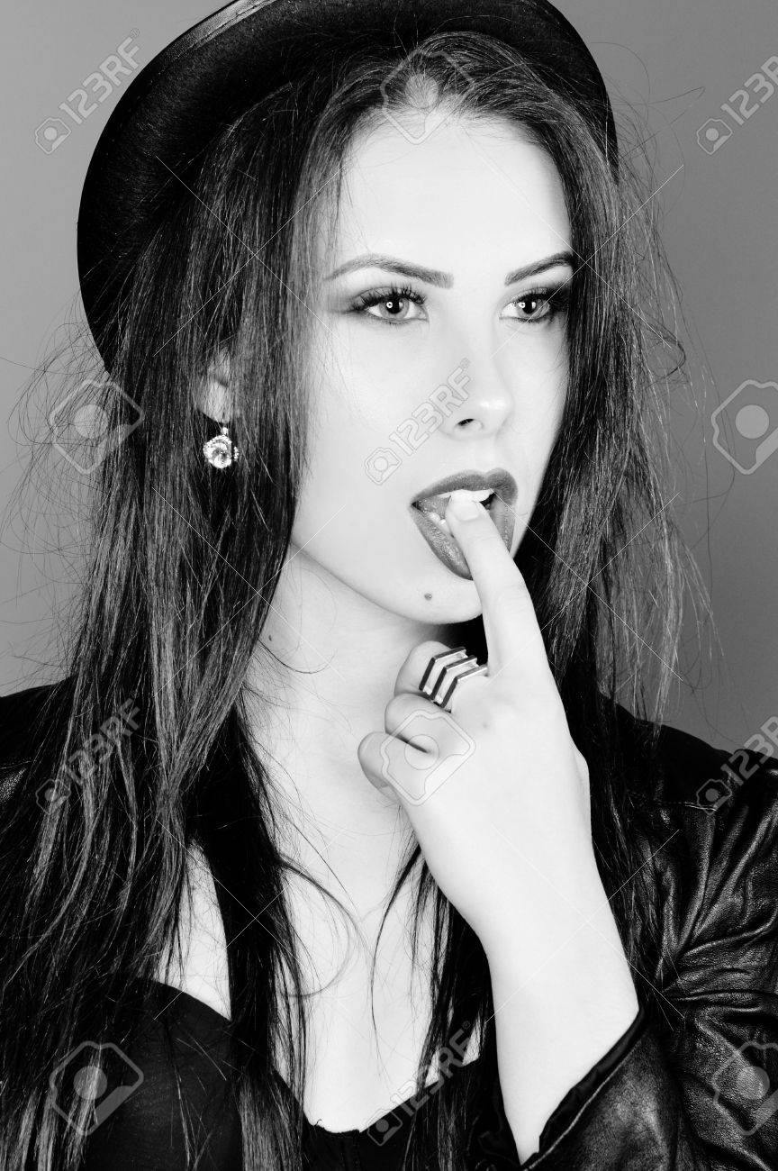 Black and white photography of hot sexy pretty lady wearing leather jacket and hat sensually looking