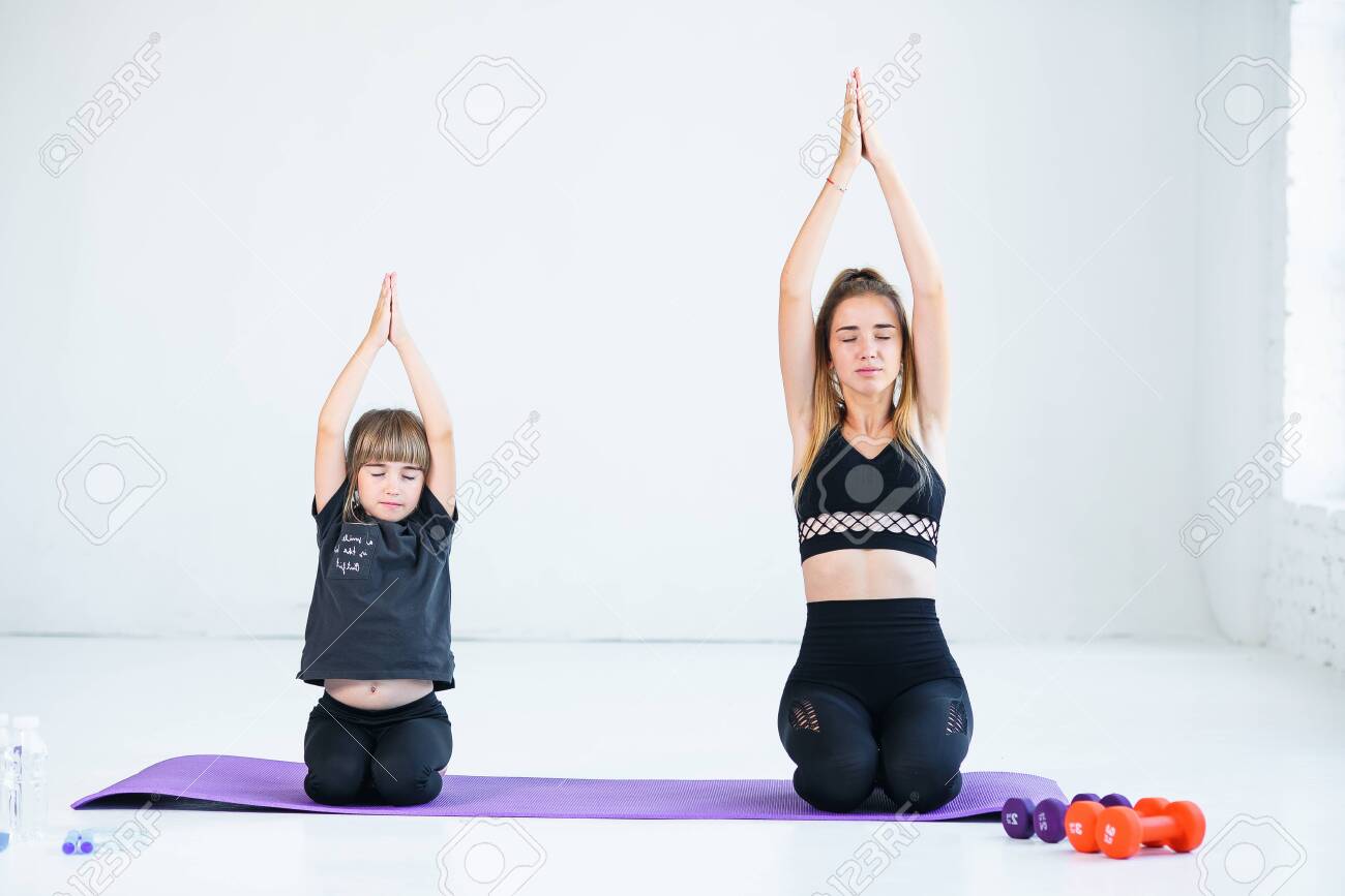 Beautiful athletic young girl and her cute little sister practicing.. Beautiful athletic young girl and her cute little sister practicing..