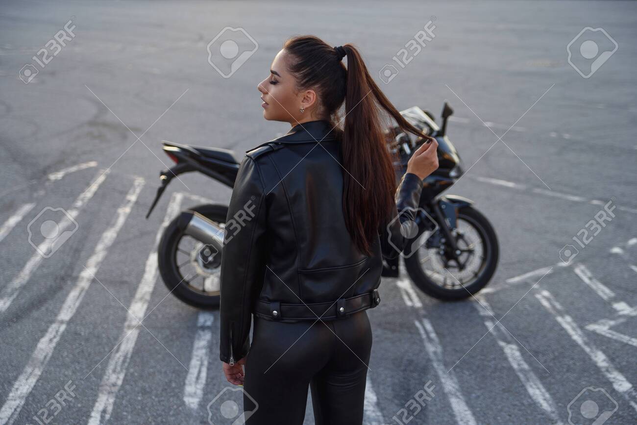 girl with long hair in a leather jacket in an underground parking lot on a motorcycle - 150964443 girl with long hair in a leather jacket in an underground parking lot on a motorcycle - 150964443