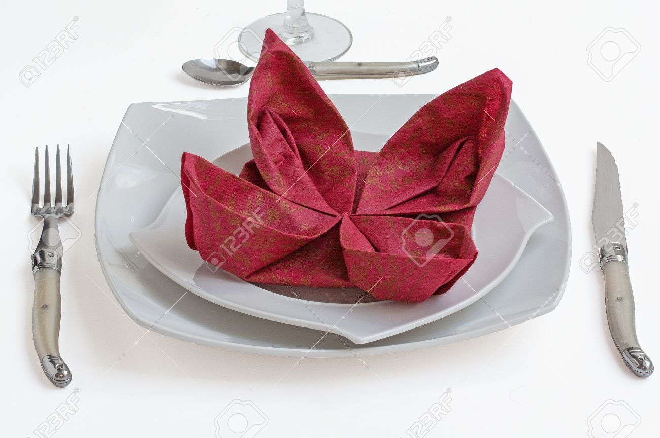 garnet paper napkin folding flower on white plate paper napkin folding flower