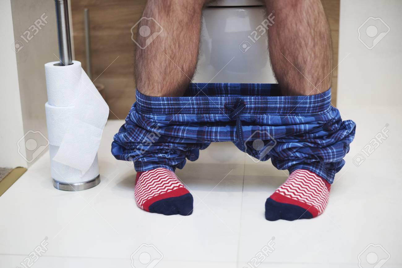 Low section of man defecating in the bathroom - 115146034 Low section of man defecating in the bathroom - 115146034