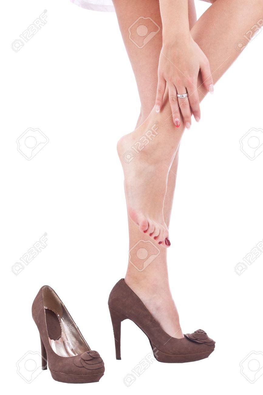 Women wearing high heels brown shoes, massaging tired legs Women wearing high heels brown shoes, massaging tired legs
