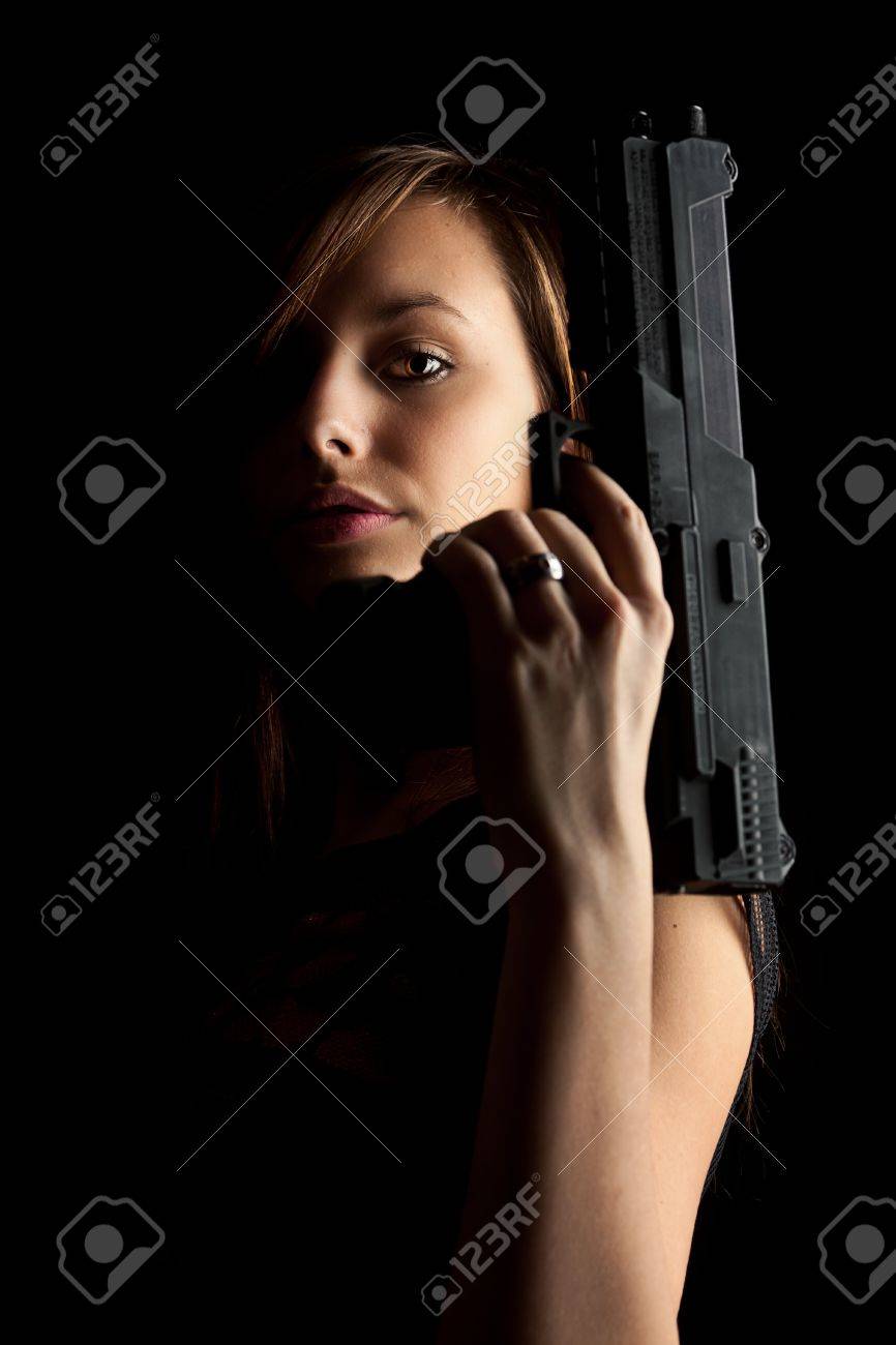 Shot Of A Beautiful Girl Holding Gun Isolated On Black Background