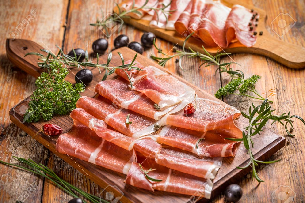 オリーブと木製のまな板にハーブと生ハムのスライス の写真素材 画像素材 Image