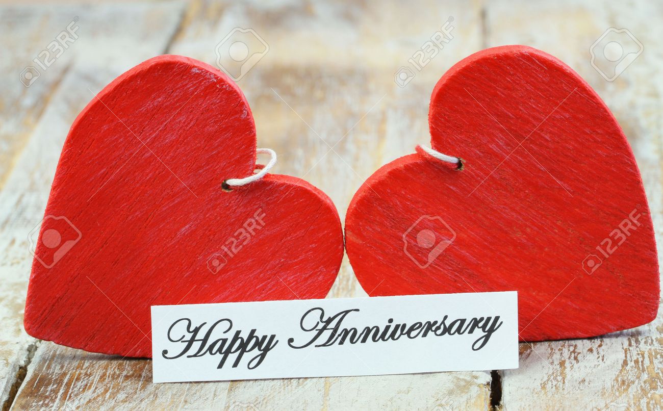 happy anniversary card with two red wooden hearts stock photo