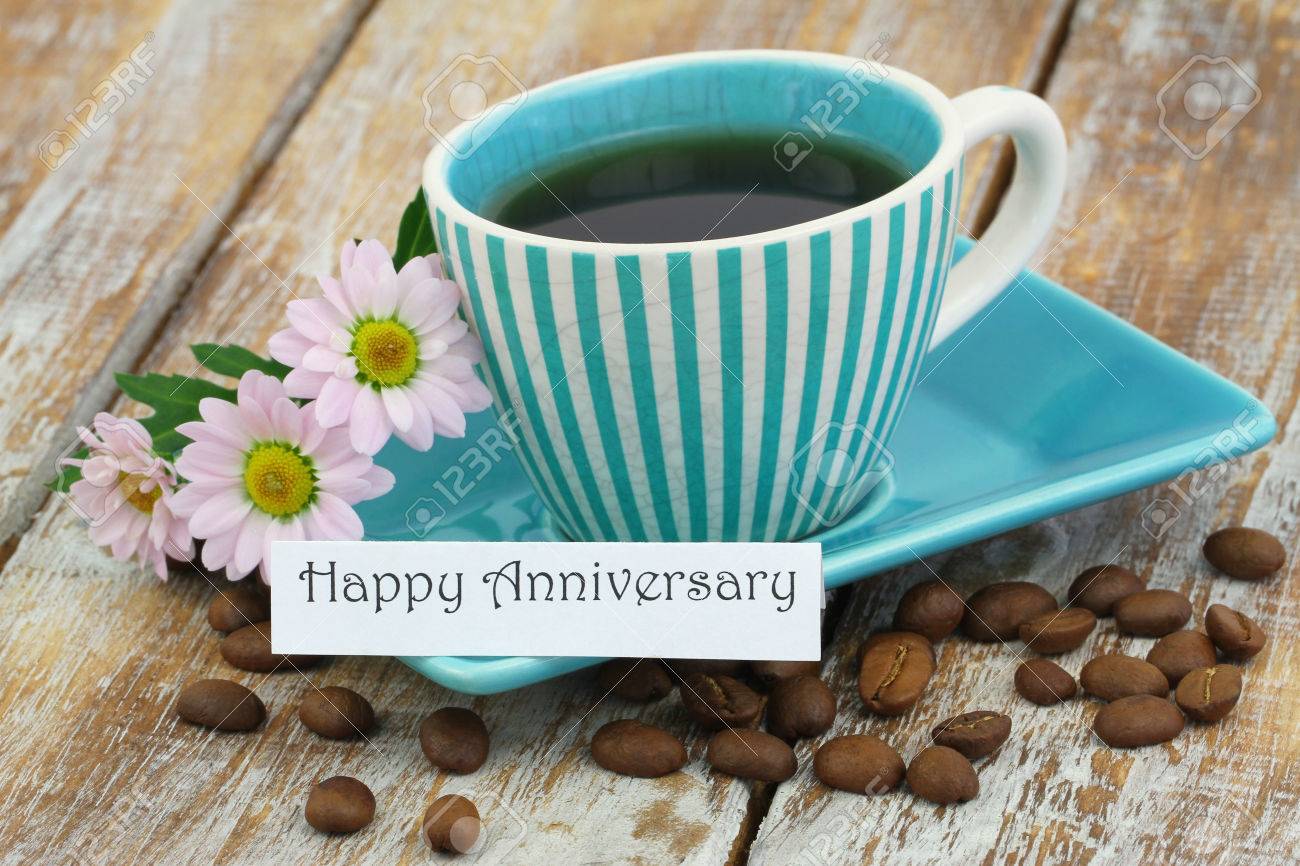 65828671-happy-anniversary-card-with-cup-of-coffee-and-pink-daisies-on-rustic-wooden-surface.jpg