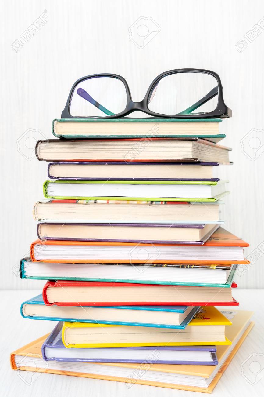 stack of books with a eyeglasses on top reading literature