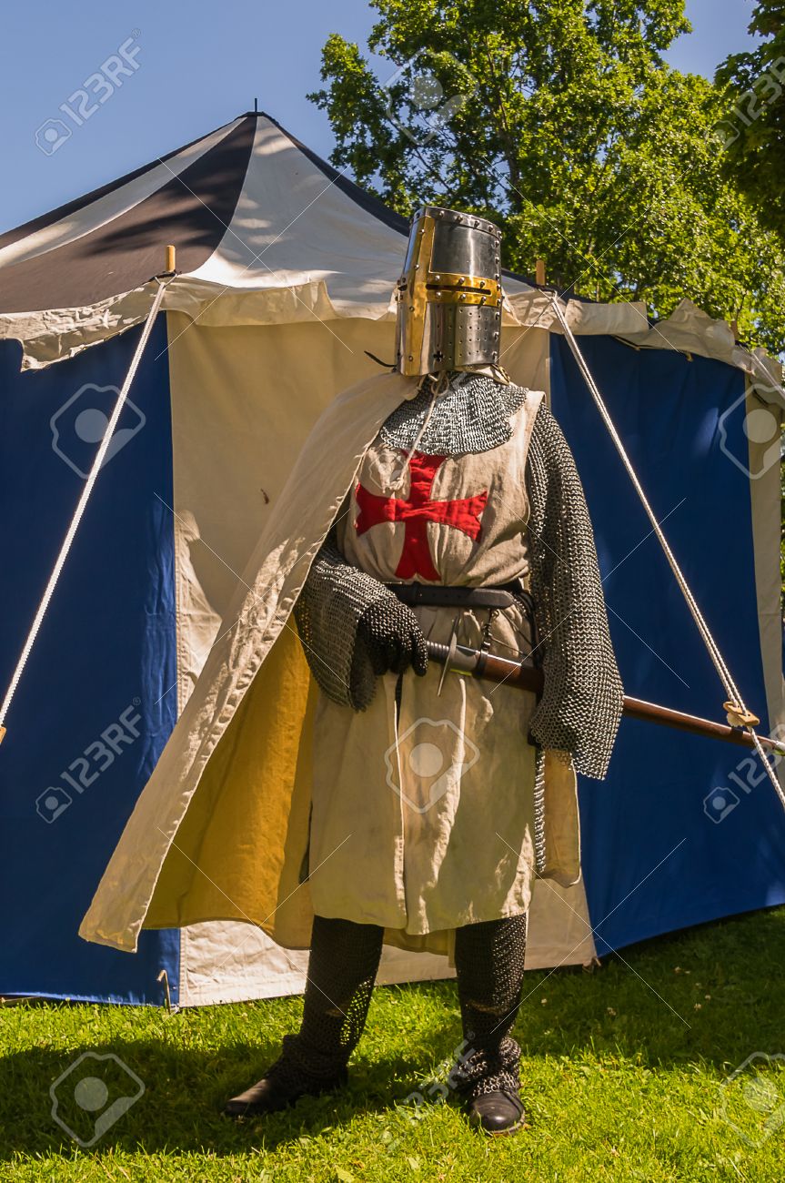 白と青テントの前に鎧状態でテンプル騎士団を模倣する歴史的に着飾った人 の写真素材 画像素材 Image