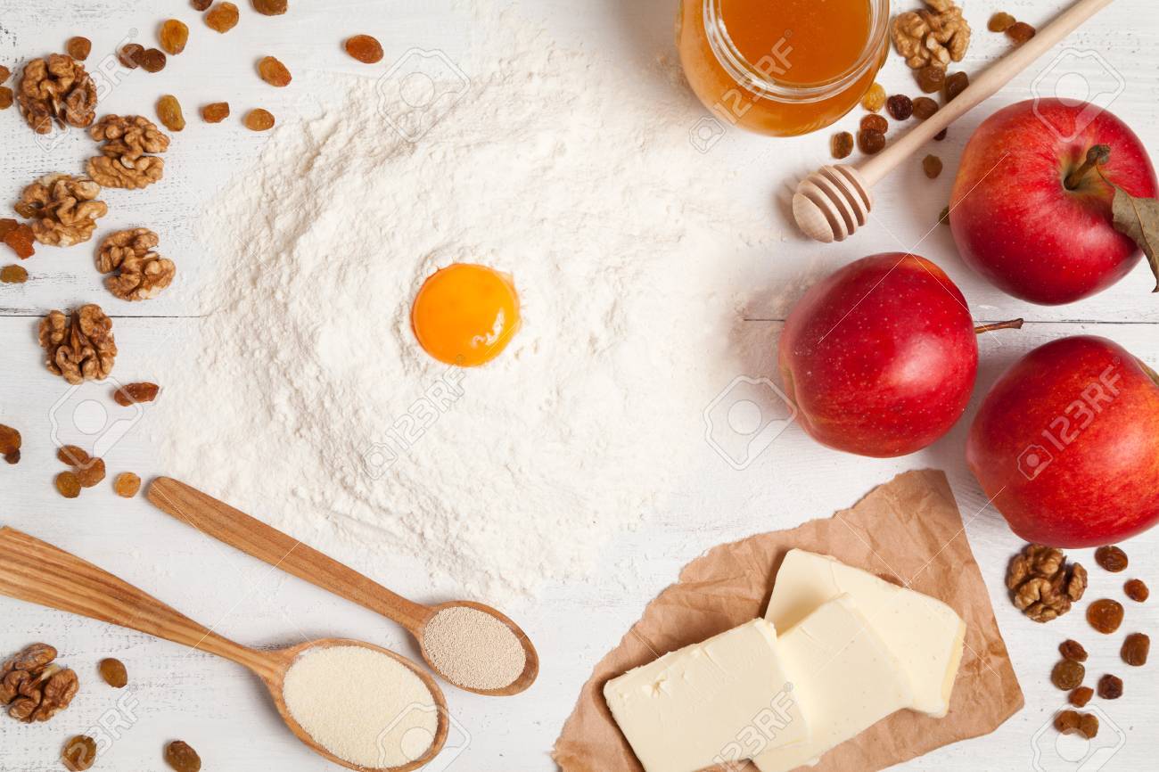 Preparation De Tarte Aux Pommes Americaine Dans La Cuisine Rustique Matieres Premieres Sur La Table Blanche Comme La Levure Le Beurre Les Pommes La Farine Les Ufs Les Raisins Secs Et De