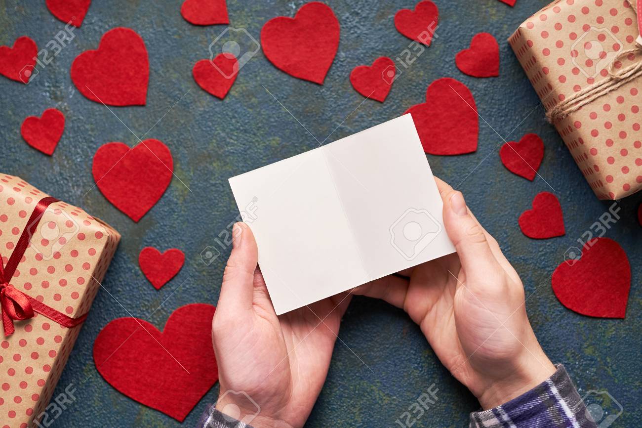 male hands holding a valentine card background with hearts and