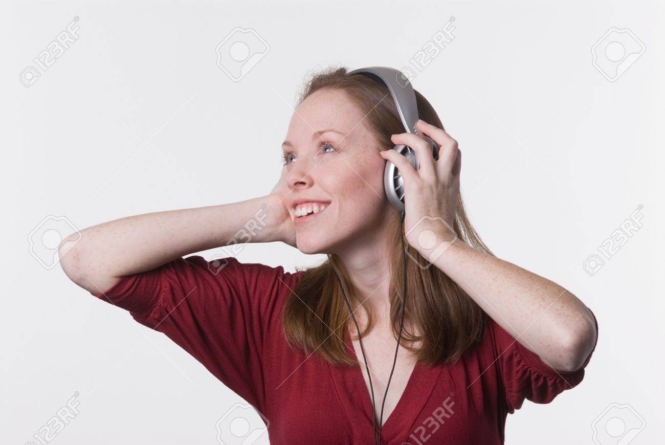 若い女性がヘッドフォンで音楽を聴いて喜んで彼女の手を保持 耳当てが の写真素材 画像素材 Image