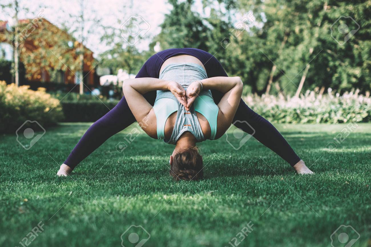 Young woman doing yoga exercise forward bend with hands in back Namaste gesture. Toned picture - 50536253 Young woman doing yoga exercise forward bend with hands in back Namaste gesture. Toned picture - 50536253