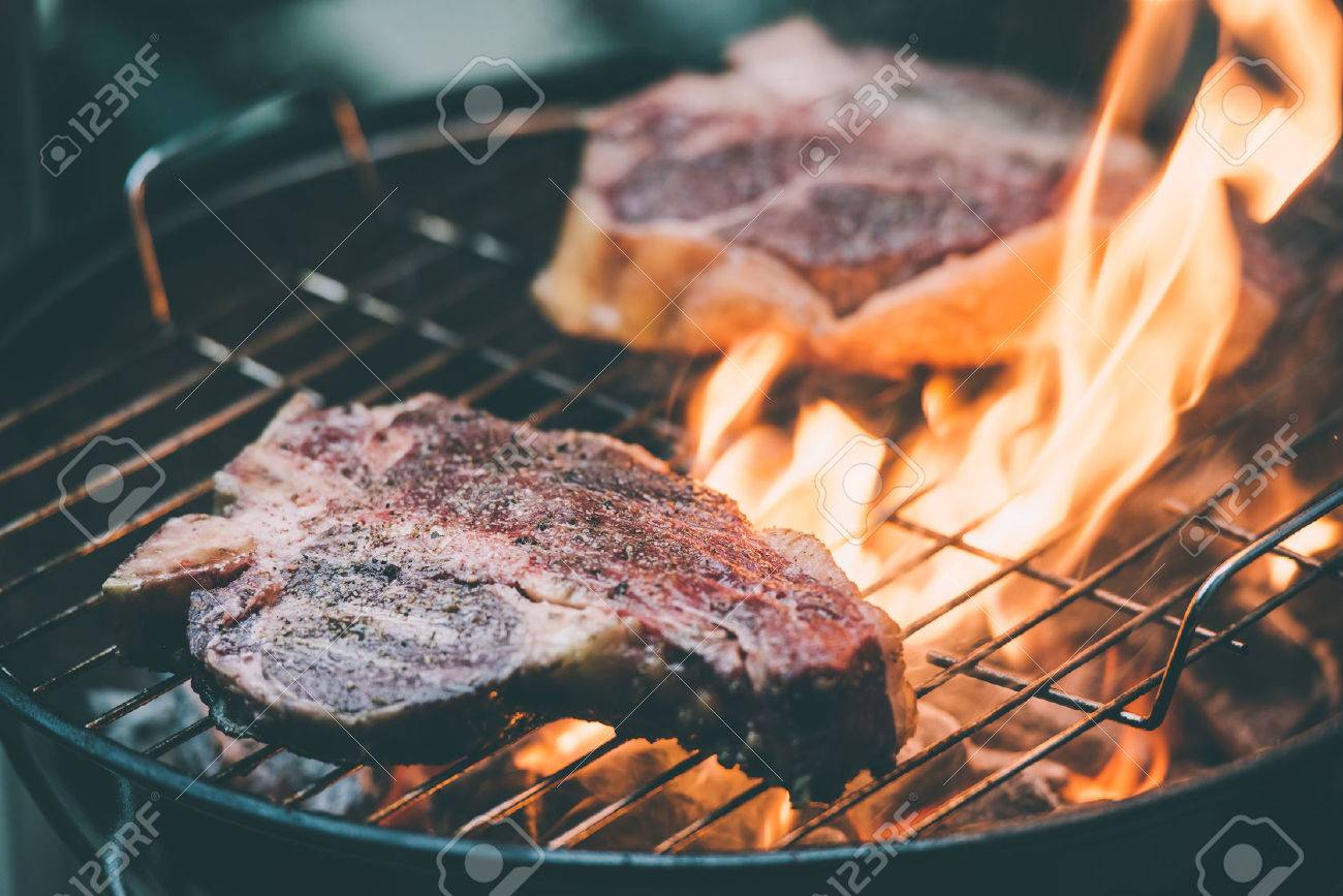 Two t-bone florentine beef steaks on the grill with flames. Toned picture - 50539315 Two t-bone florentine beef steaks on the grill with flames. Toned picture - 50539315
