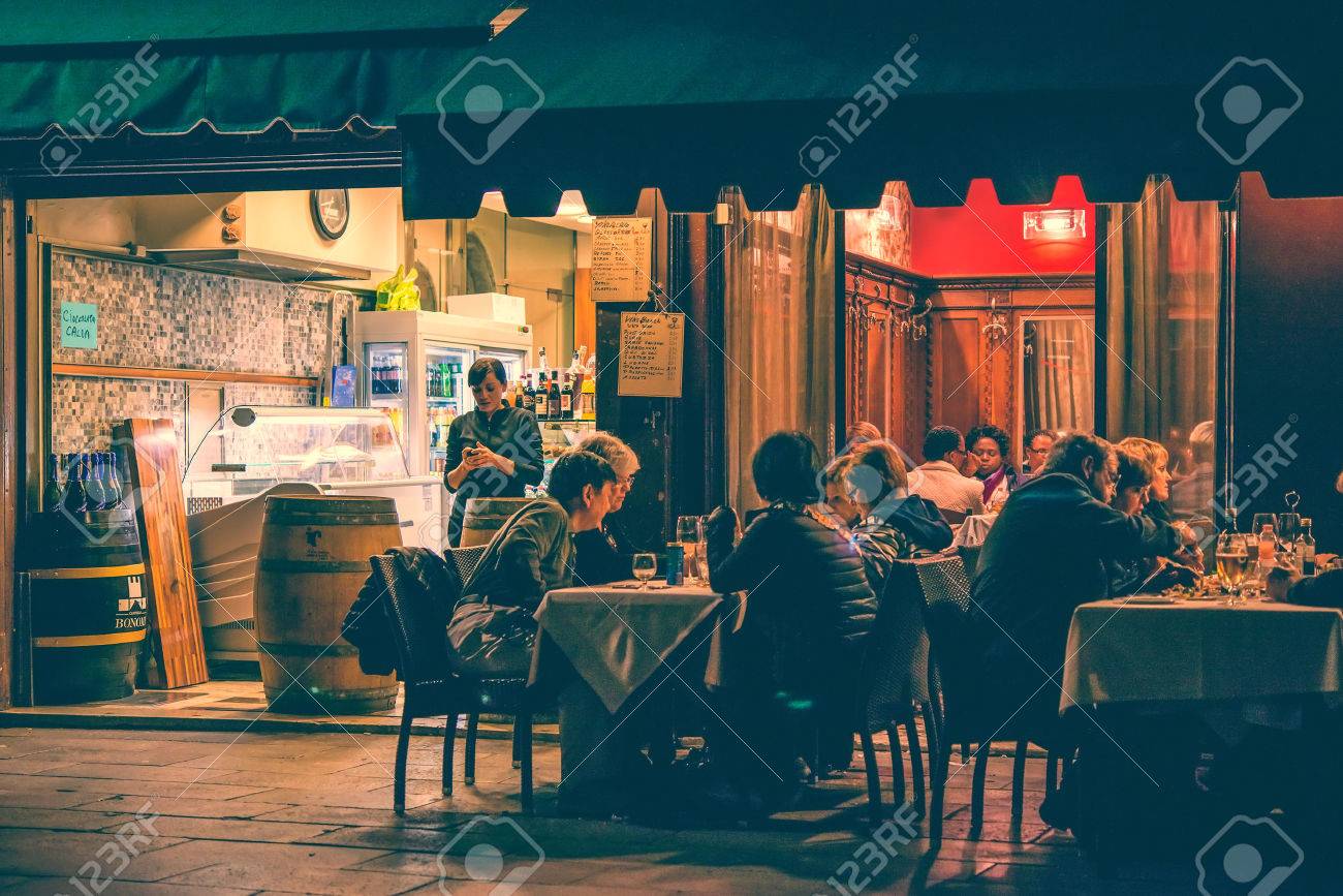VENICE, ITALY - OCTOBER 11: People are sitting at the outside terrace of a small cafe in the evening in Venice, Italy. Toned picture - 53869822 VENICE, ITALY - OCTOBER 11: People are sitting at the outside terrace of a small cafe in the evening in Venice, Italy. Toned picture - 53869822