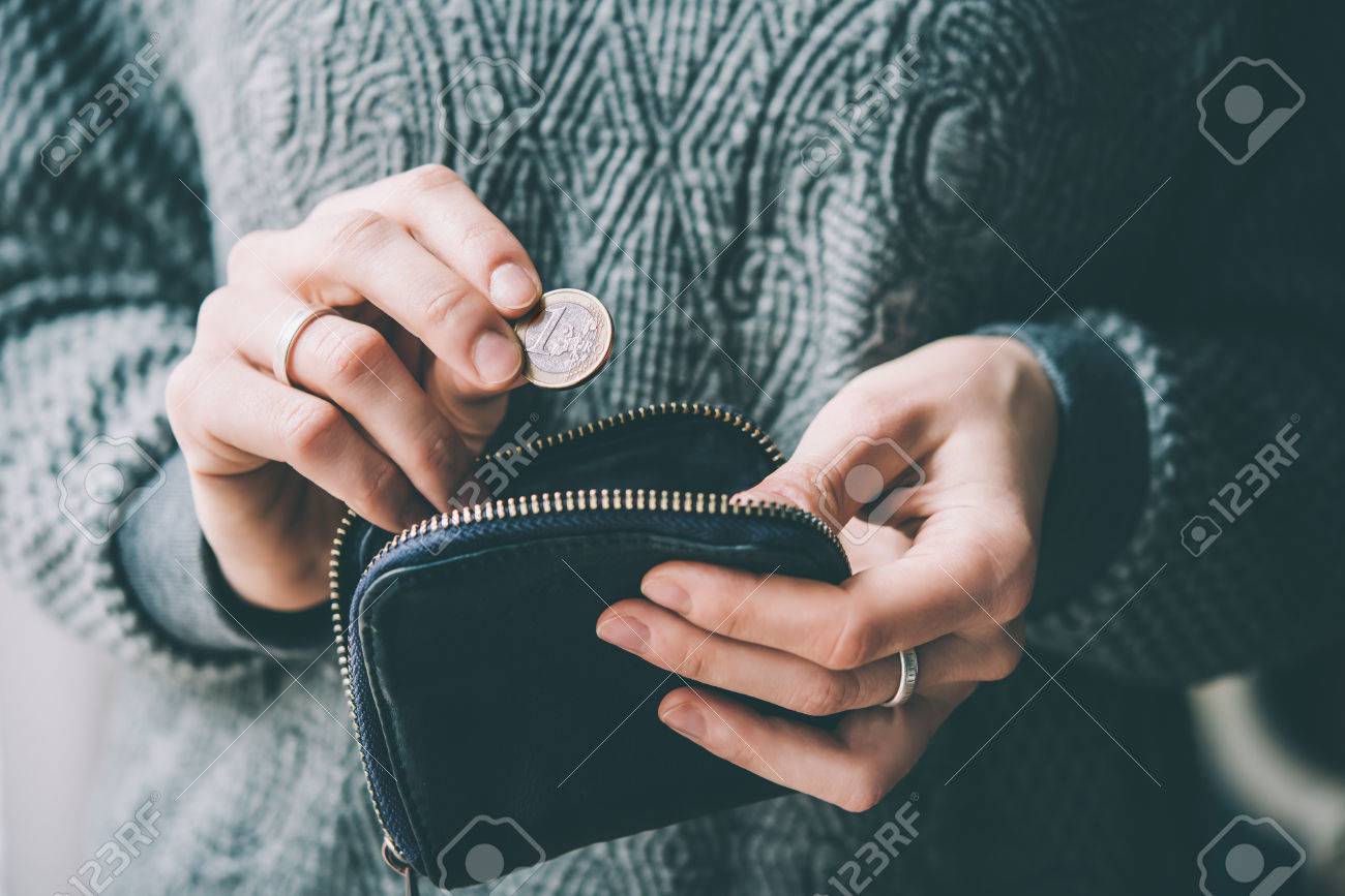 Hands holding one euro coin and small money pouch. Toned picture - 55416884 Hands holding one euro coin and small money pouch. Toned picture - 55416884