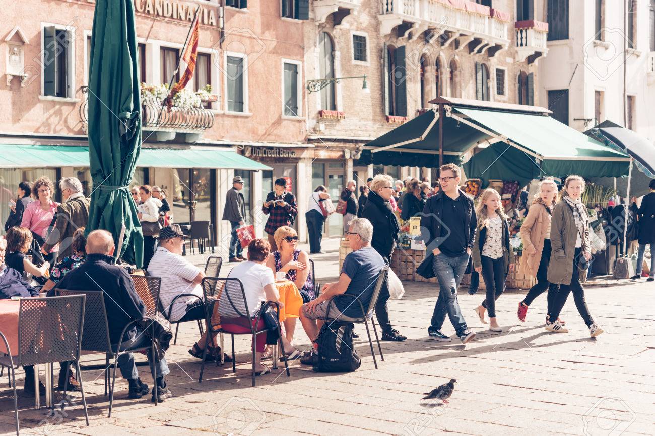 VENICE, ITALY - OCTOBER 11: People are sitting at the outside terrace of a small cafe in Venice, Italy. Toned picture - 53869914 VENICE, ITALY - OCTOBER 11: People are sitting at the outside terrace of a small cafe in Venice, Italy. Toned picture - 53869914