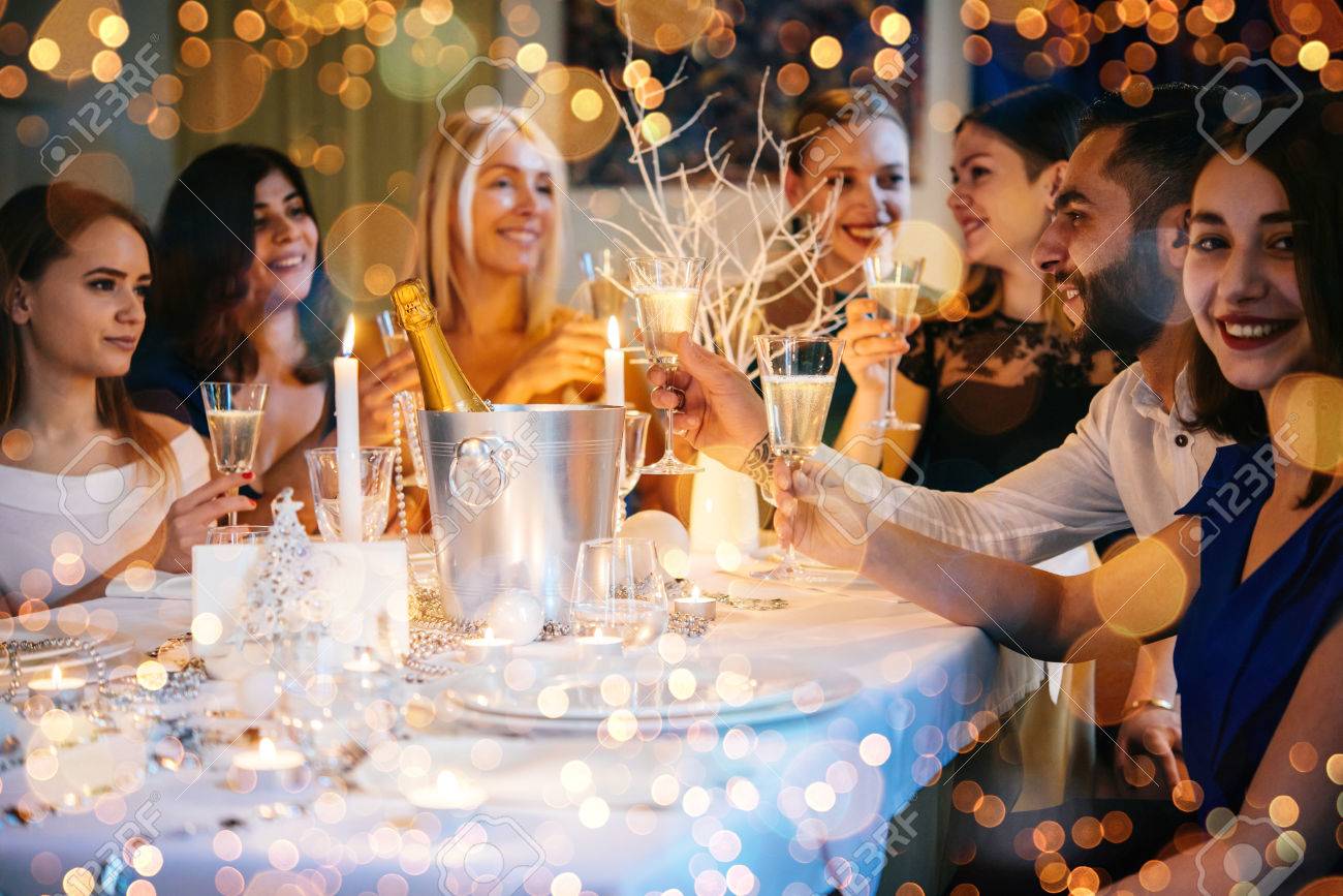 Friends celebrating Christmas or New Year eve. Party table with champagne. - 69759412 Friends celebrating Christmas or New Year eve. Party table with champagne. - 69759412
