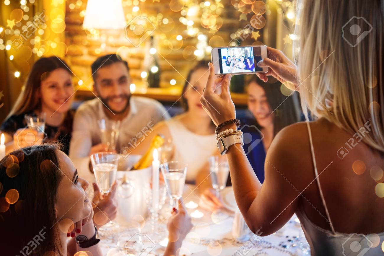 Friends celebrating Christmas or New Year eve. Party table with champagne. - 69759388 Friends celebrating Christmas or New Year eve. Party table with champagne. - 69759388
