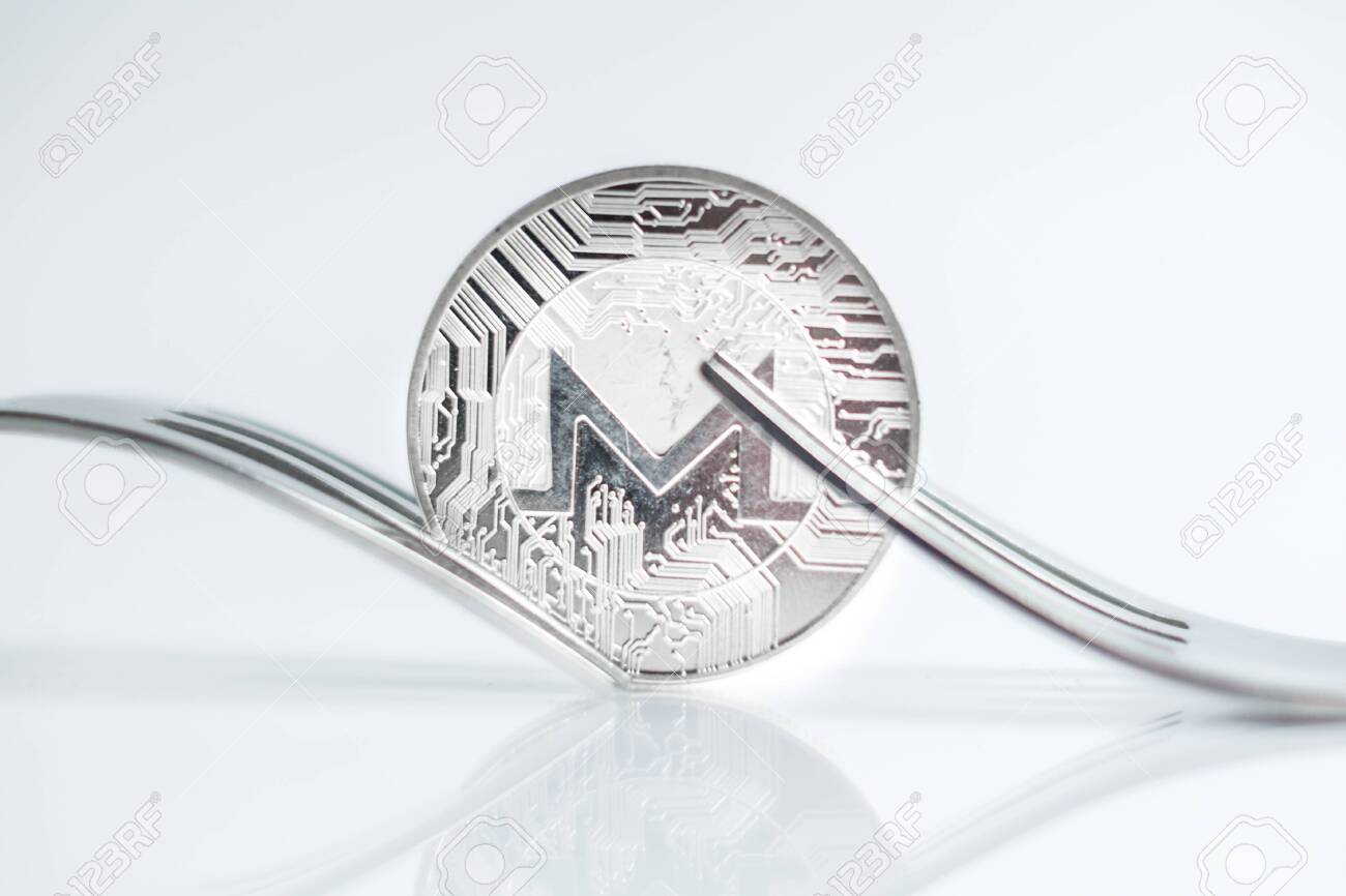 Monero Cryptocurreny Coin Placed Between Forks With Reflection, Hard Fork  Фотография, картинки, изображения и сток-фотография без роялти. Image  123389706