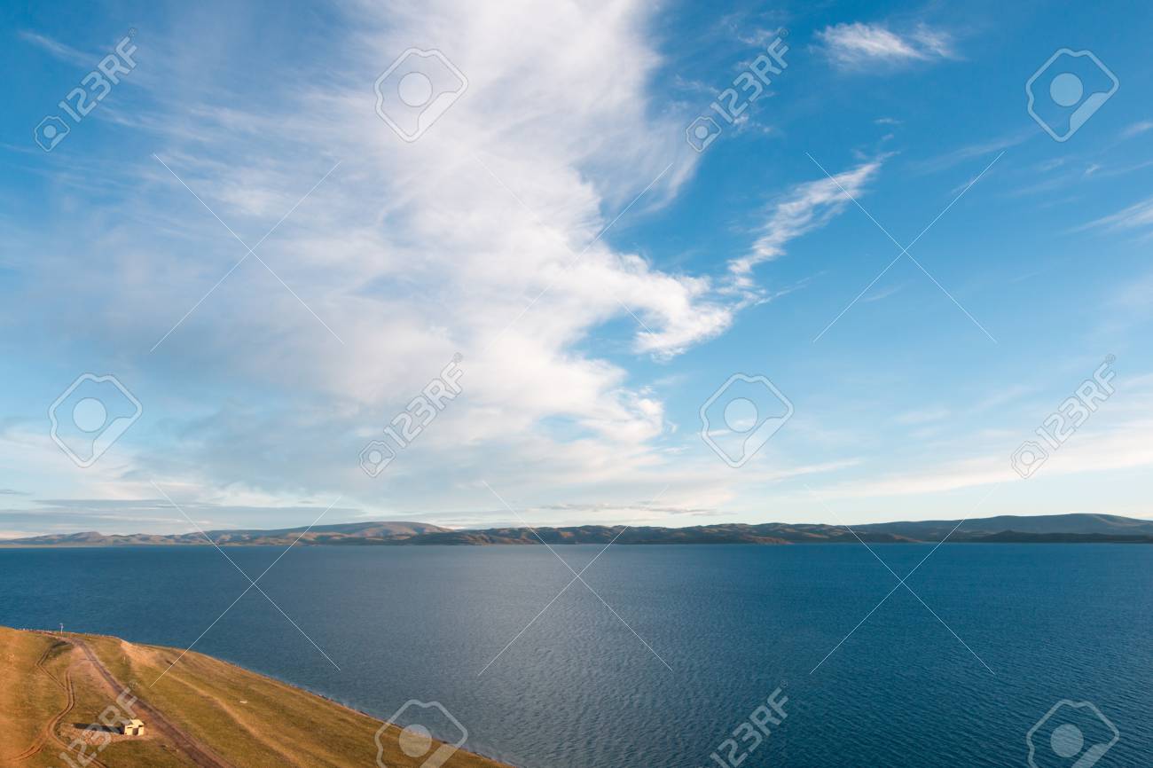 ナムツォ湖太陽は水平線 白い雲の大きなブロックのを超えて上昇した後の全景キャンディのチベット 中国の朝の澄んだ青い空に浮かんでいるように見えます の写真素材 画像素材 Image