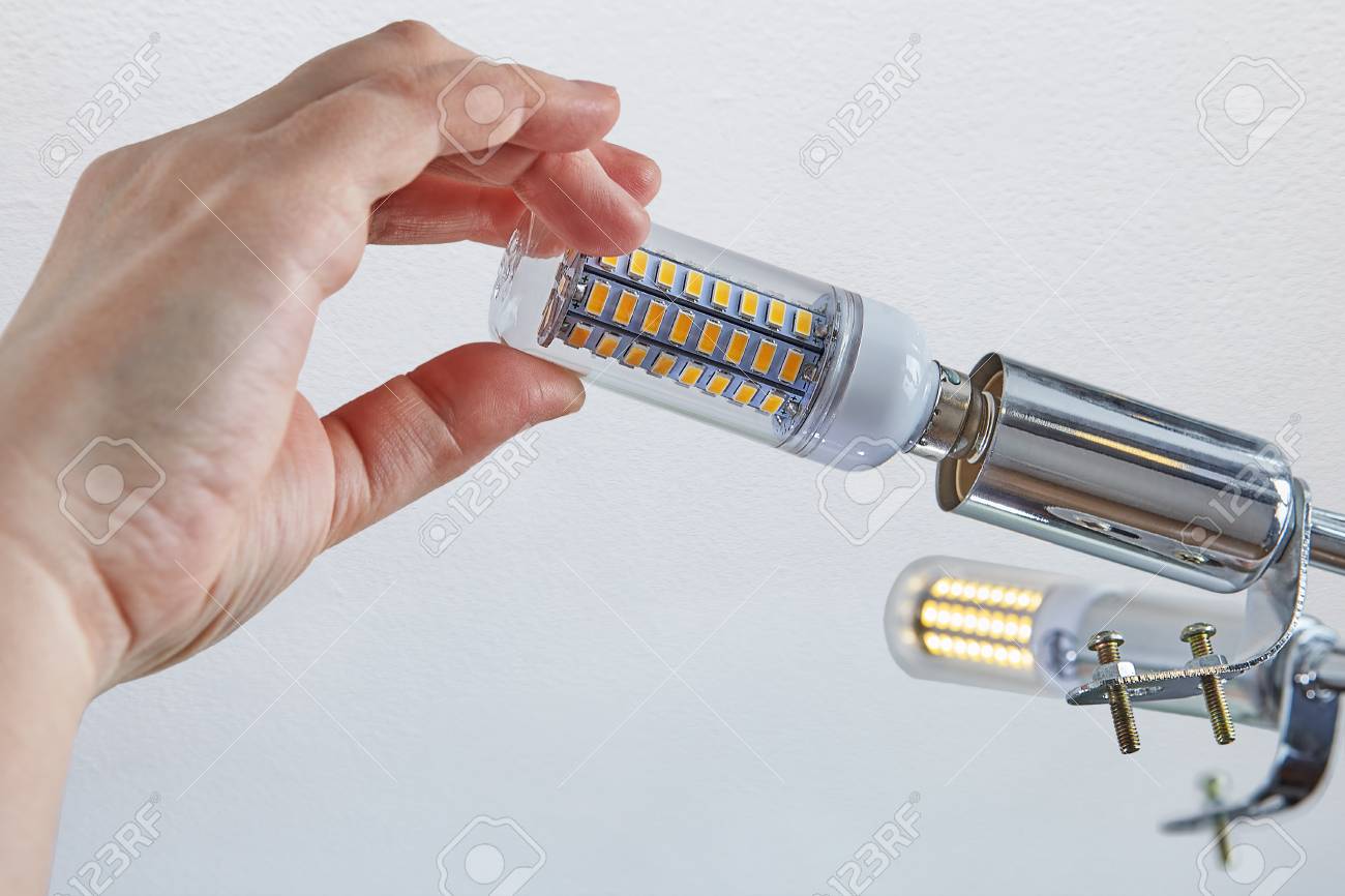Replacing Lamps In Ceiling Light Close Up Of Female Hand Is