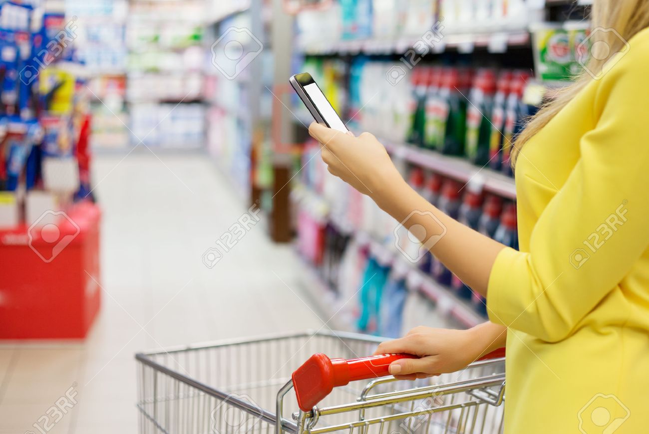 mujer que controla la lista de compras en su teléfono inteligente en